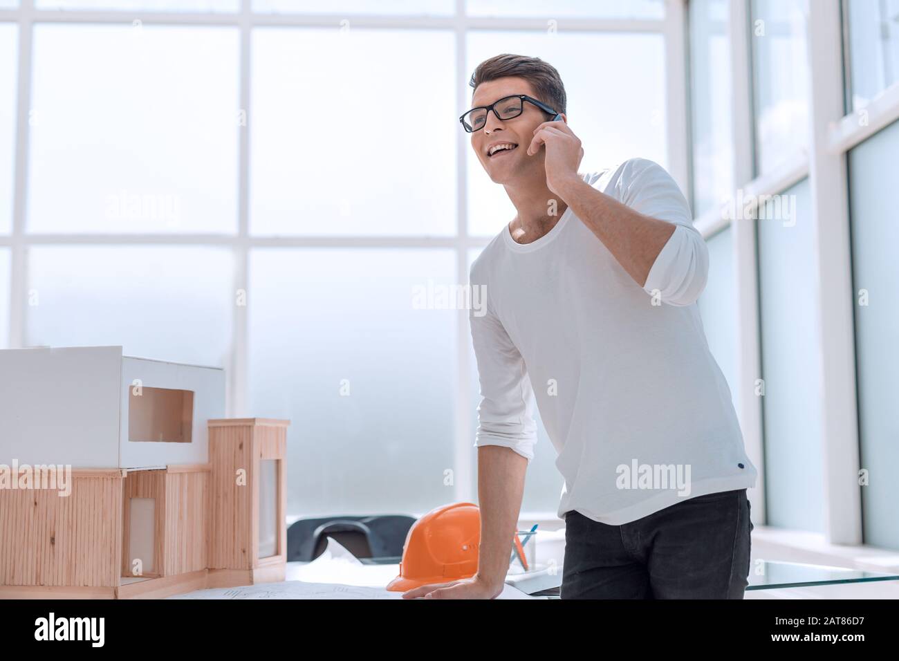 Concepteur réussi à parler sur son smartphone dans Design Studio. Banque D'Images