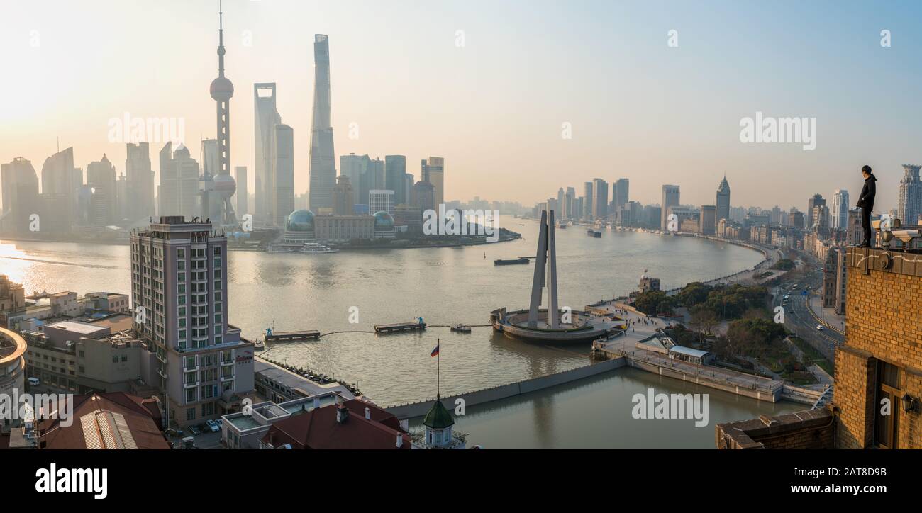Homme admirant la vue sur la rivière Huangpu et les gratte-ciel de Shanghai en début de matinée, Shanghai, Chine Banque D'Images