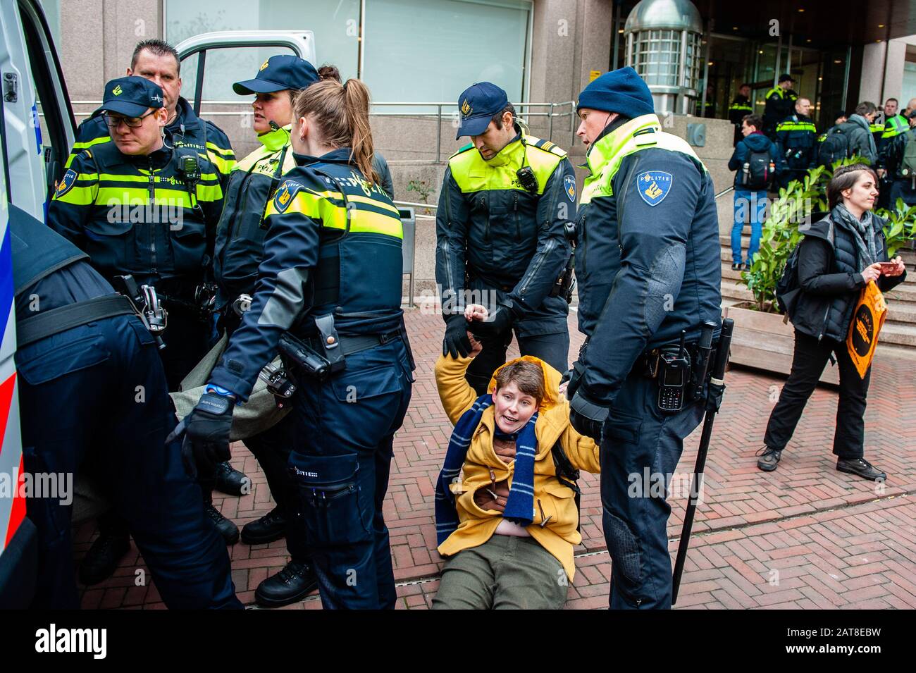 Une militante de la XR féminine regarde la caméra tout en étant arrêtée pendant la campagne. Une vingtaine d'activistes de la rébellion de l'extinction du groupe ont montré au siège de Shell dans le cadre de la campagne que Shell doit tomber, qui se déroule toute la semaine dans tout le pays. Certains militants de l'extinction se sont collés aux fenêtres et aux portes en cristal du bâtiment. Après avoir refusé de quitter le lieu, la plupart d'entre eux ont été arrêtés par la police. Banque D'Images