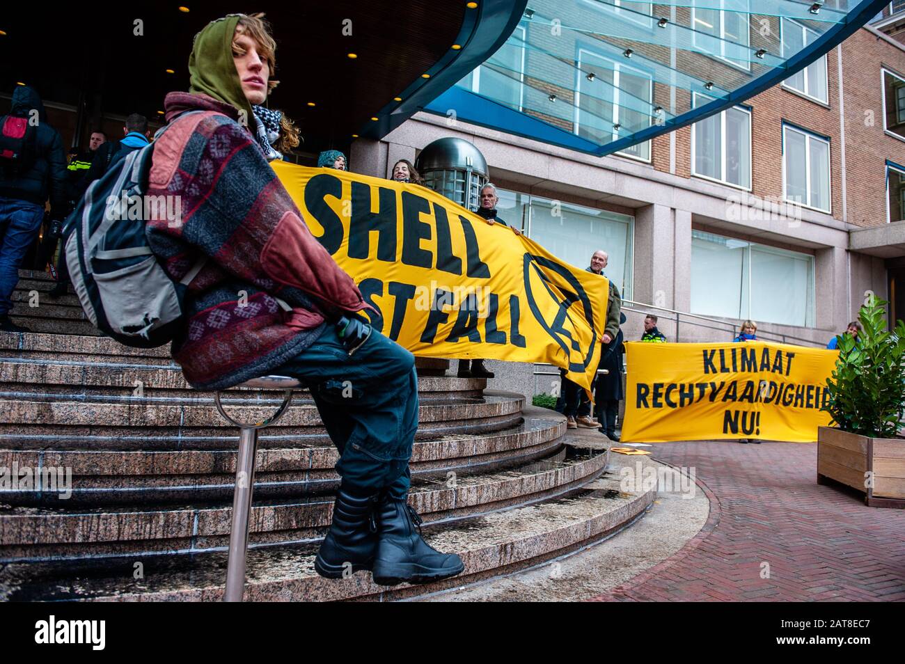 Un militant du XR s'asseoir à côté d'une immense bannière pendant la campagne. Une vingtaine d'activistes de la rébellion de l'extinction du groupe se sont manifesté au siège de Shell dans le cadre de la campagne que Shell doit faire, qui se déroule toute la semaine dans tout le pays. Certains militants de l'extinction se sont collés aux fenêtres et aux portes en cristal du bâtiment. Après avoir refusé de quitter le lieu, la plupart d'entre eux ont été arrêtés par la police. Banque D'Images