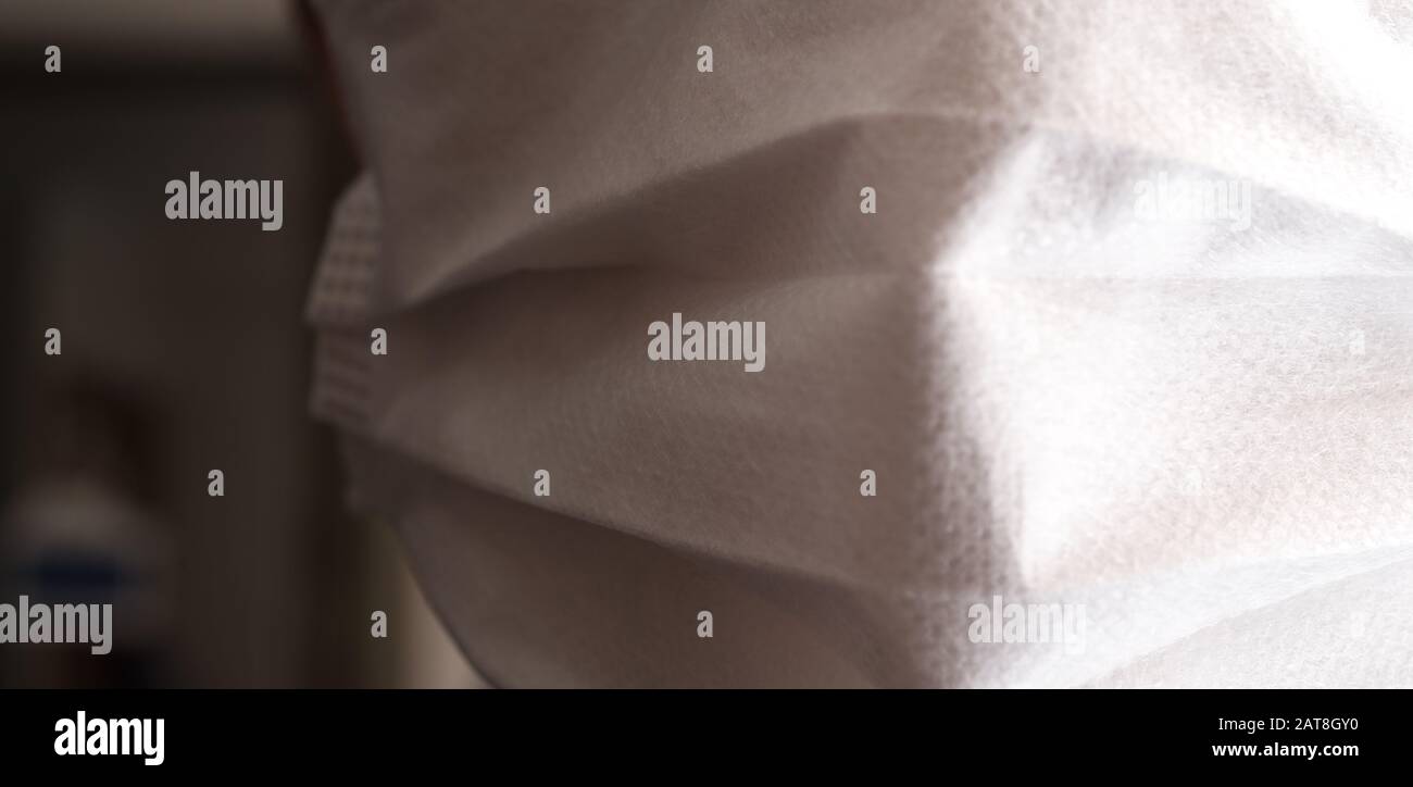 Gros plan sur le visage d'un jeune homme portant un masque médical ou chirurgical Banque D'Images