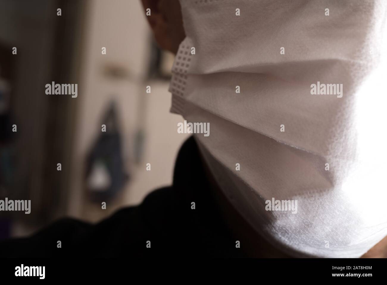 Gros plan sur le visage d'un jeune homme portant un masque médical ou chirurgical Banque D'Images