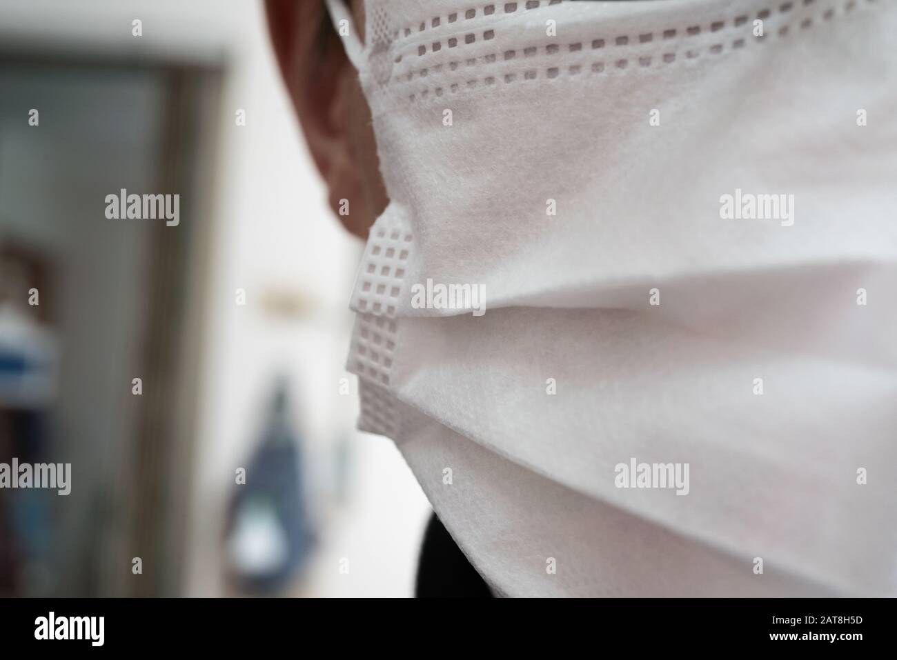 Gros plan sur le visage d'un jeune homme portant un masque médical ou chirurgical Banque D'Images