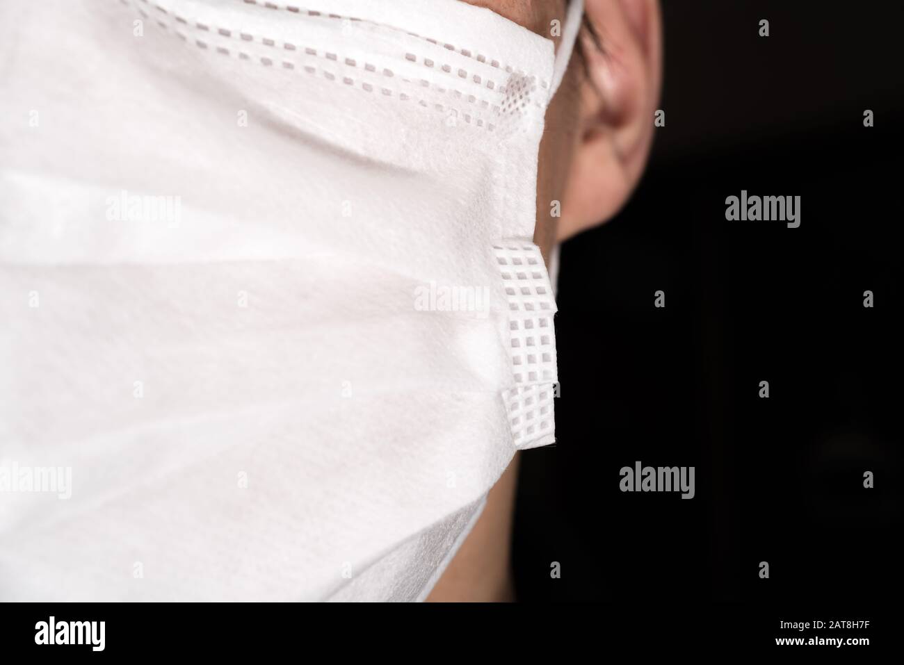 Gros plan sur le visage d'un jeune homme portant un masque médical ou chirurgical Banque D'Images