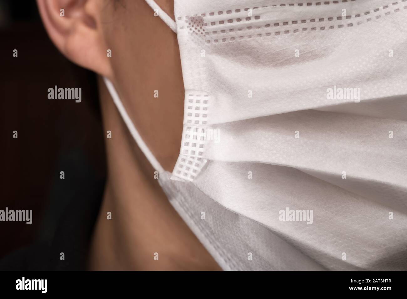 Gros plan sur le visage d'un jeune homme portant un masque médical ou chirurgical Banque D'Images