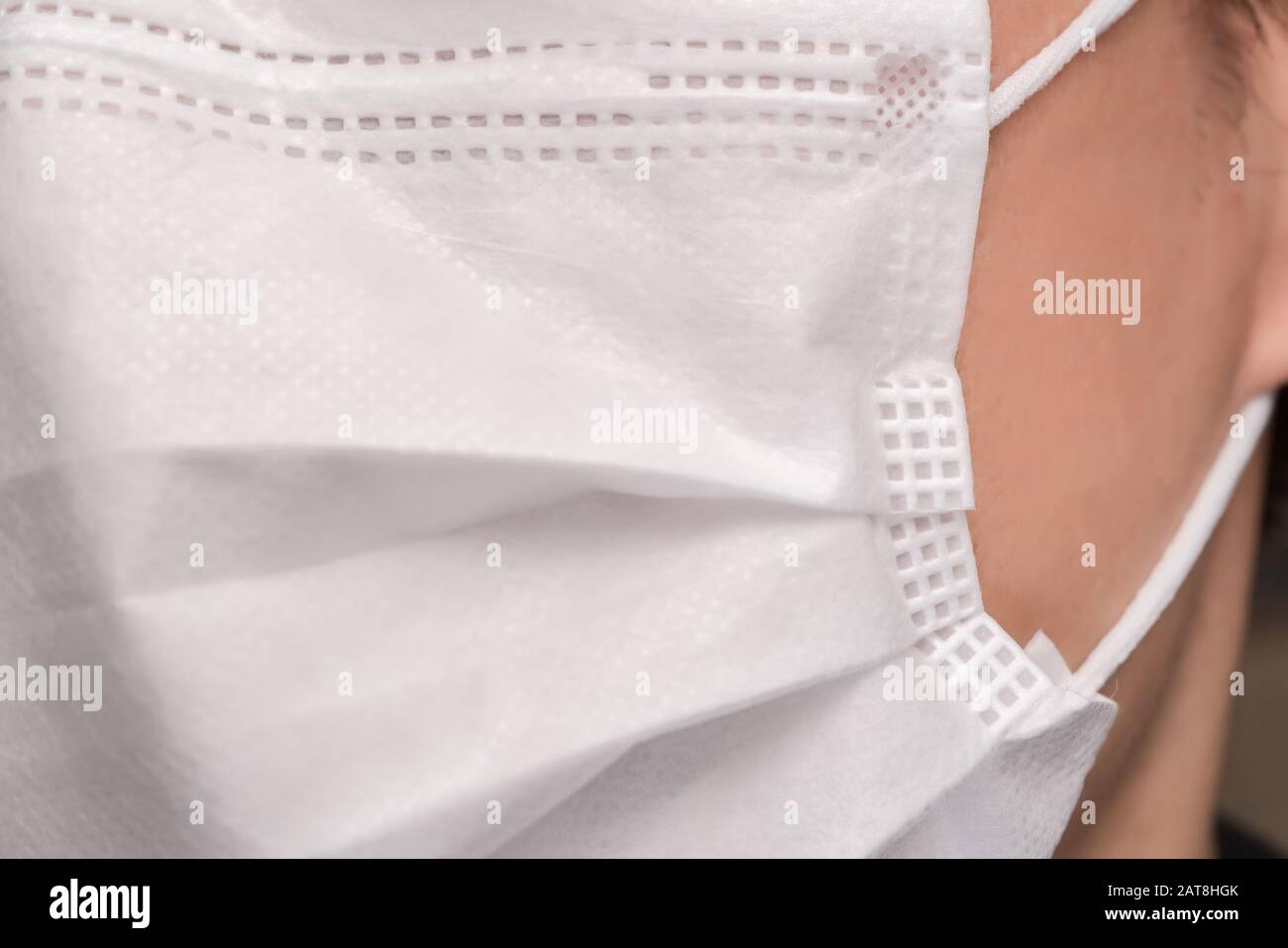 Gros plan sur le visage d'un jeune homme portant un masque médical ou chirurgical Banque D'Images