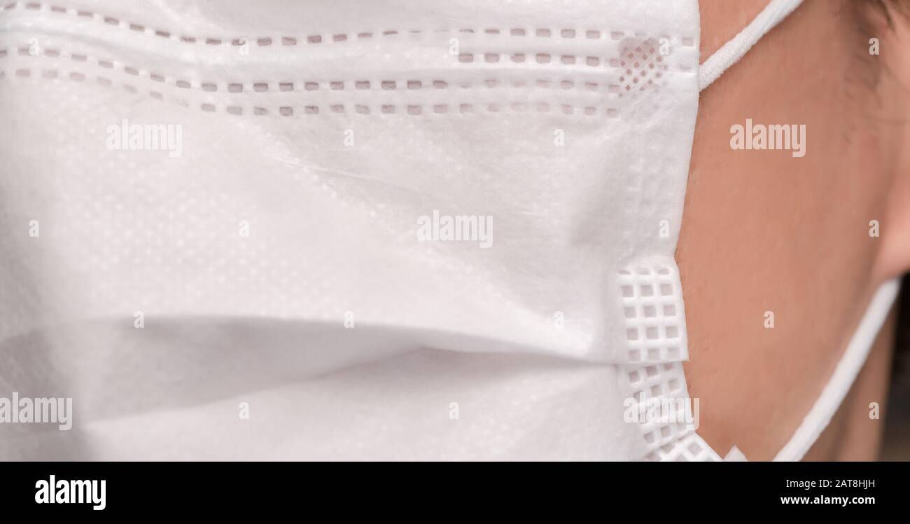 Gros plan sur le visage d'un jeune homme portant un masque médical ou chirurgical Banque D'Images