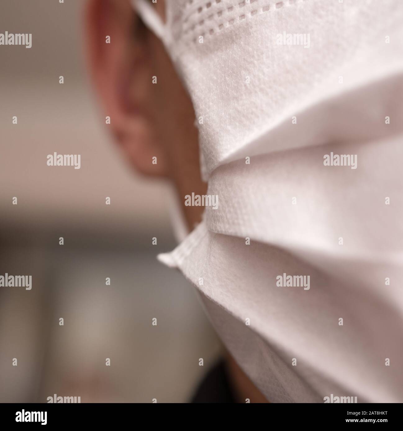 Gros plan sur le visage d'un jeune homme portant un masque médical ou chirurgical Banque D'Images