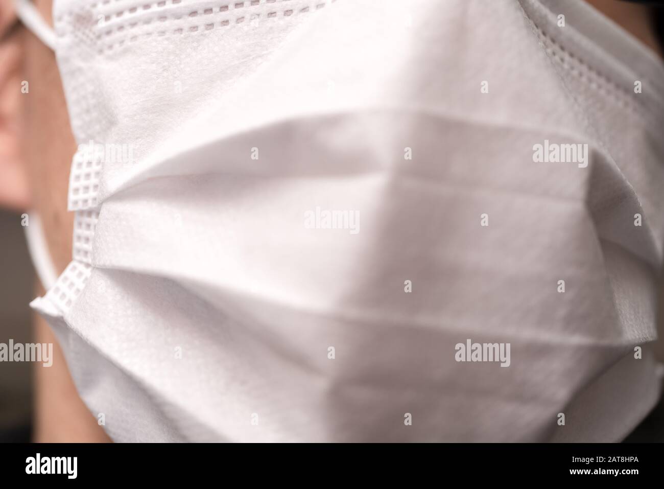 Gros plan sur le visage d'un jeune homme portant un masque médical ou chirurgical Banque D'Images