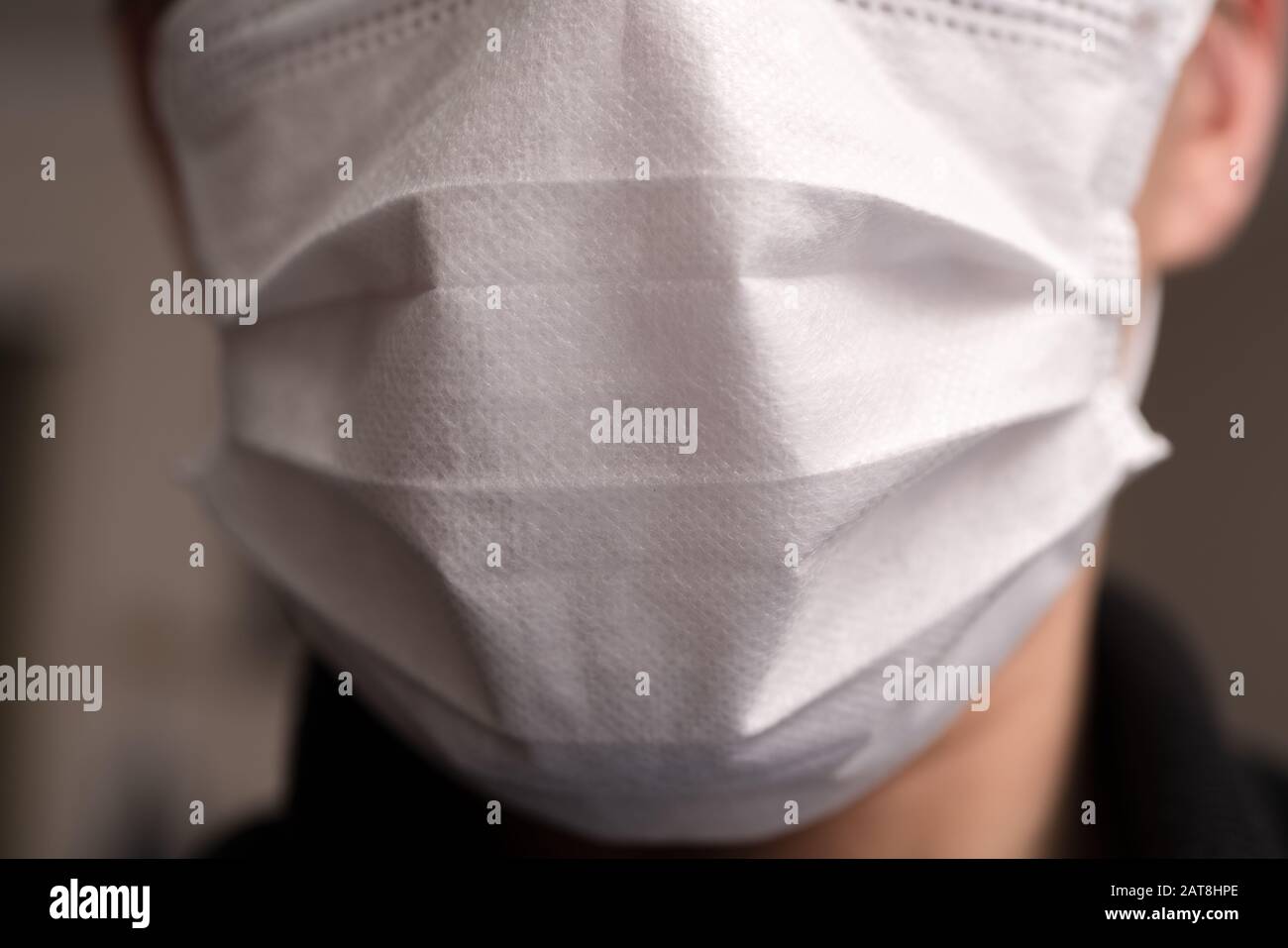 Gros plan sur le visage d'un jeune homme portant un masque médical ou chirurgical Banque D'Images