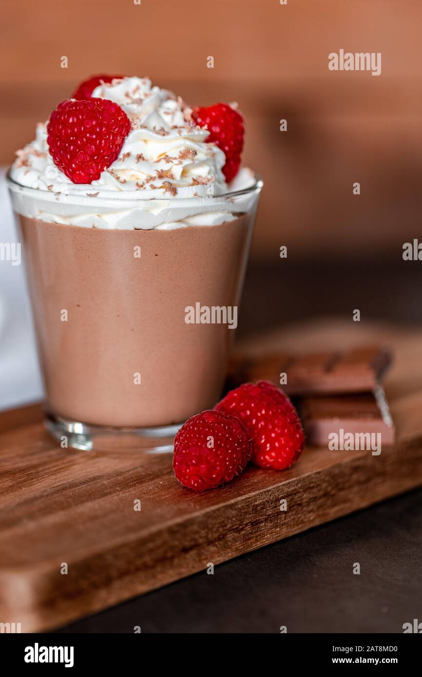 Mousse au chocolat maison avec crème fouettée, framboises et copeaux de chocolat sur le dessus Banque D'Images