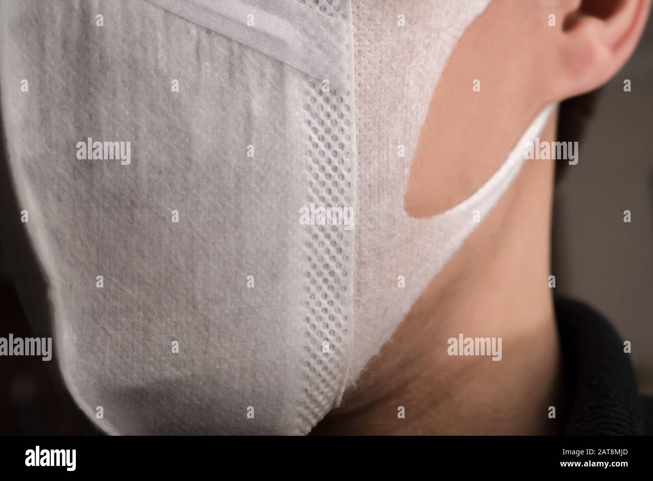 Gros plan sur le visage d'un jeune homme portant un masque médical ou chirurgical Banque D'Images