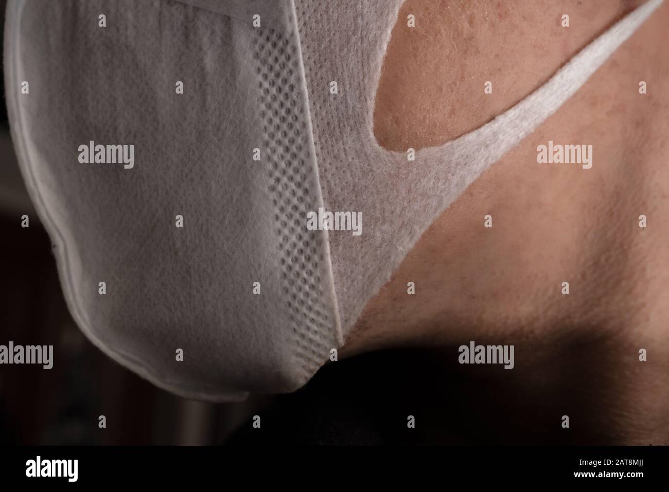 Gros plan sur le visage d'un jeune homme portant un masque médical ou chirurgical Banque D'Images