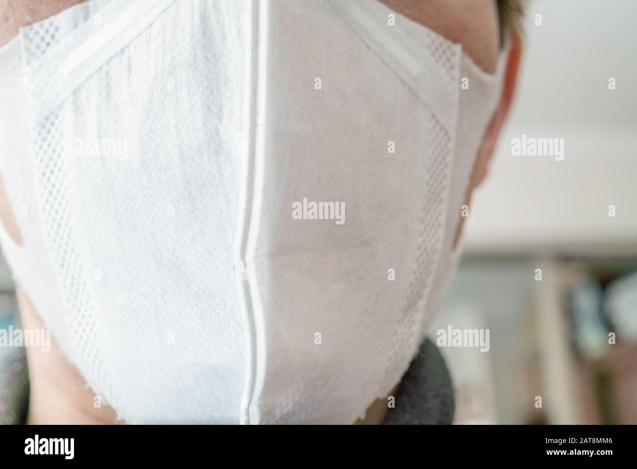 Gros plan sur le visage d'un jeune homme portant un masque médical ou chirurgical Banque D'Images