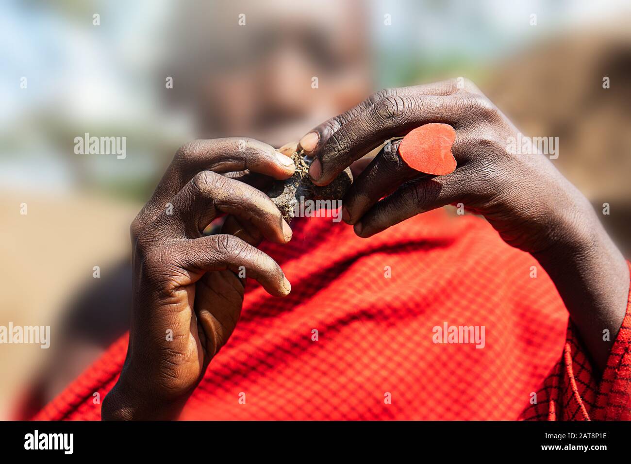 Homme africain tenant un gâteau à la couvée dans ses mains avec un anneau de coeur rouge. Tanzanie, Afrique. Mise au point sélective. Banque D'Images