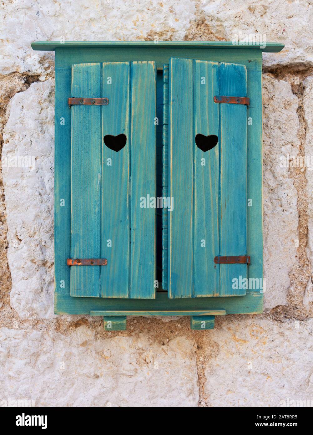 Un trou en forme de coeur dans les volets en bois bleu pittoresque sur la  fenêtre d'une ancienne maison croate en pierre. Photo romantique pour la  Saint-Valentin Photo Stock - Alamy