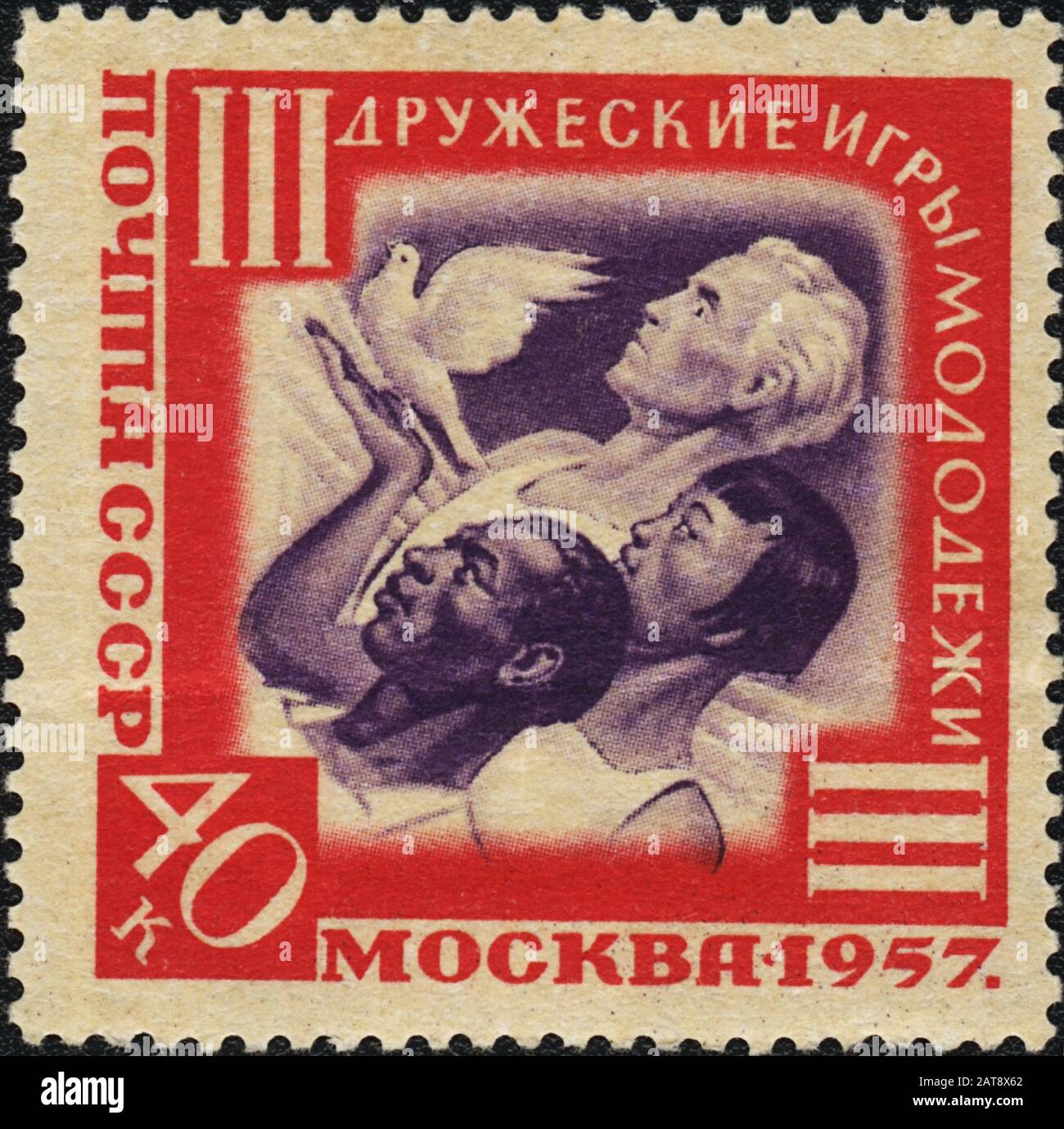 Timbre-poste: Colombe blanche de paix entre les mains des jeunes. III jeux de jeunes d'amitié à Moscou, URSS, 1957 Banque D'Images