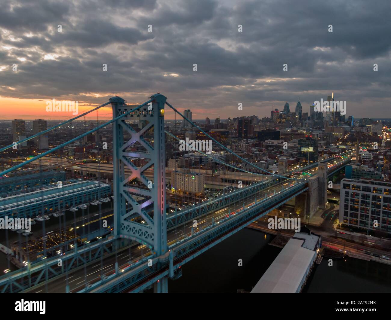 Philadelphie la nuit, vue aérienne de la skzline au coucher du soleil avec Benjamin Franklin Bridge et front de mer, gratte-ciel dominant cityline contre dramatique Banque D'Images