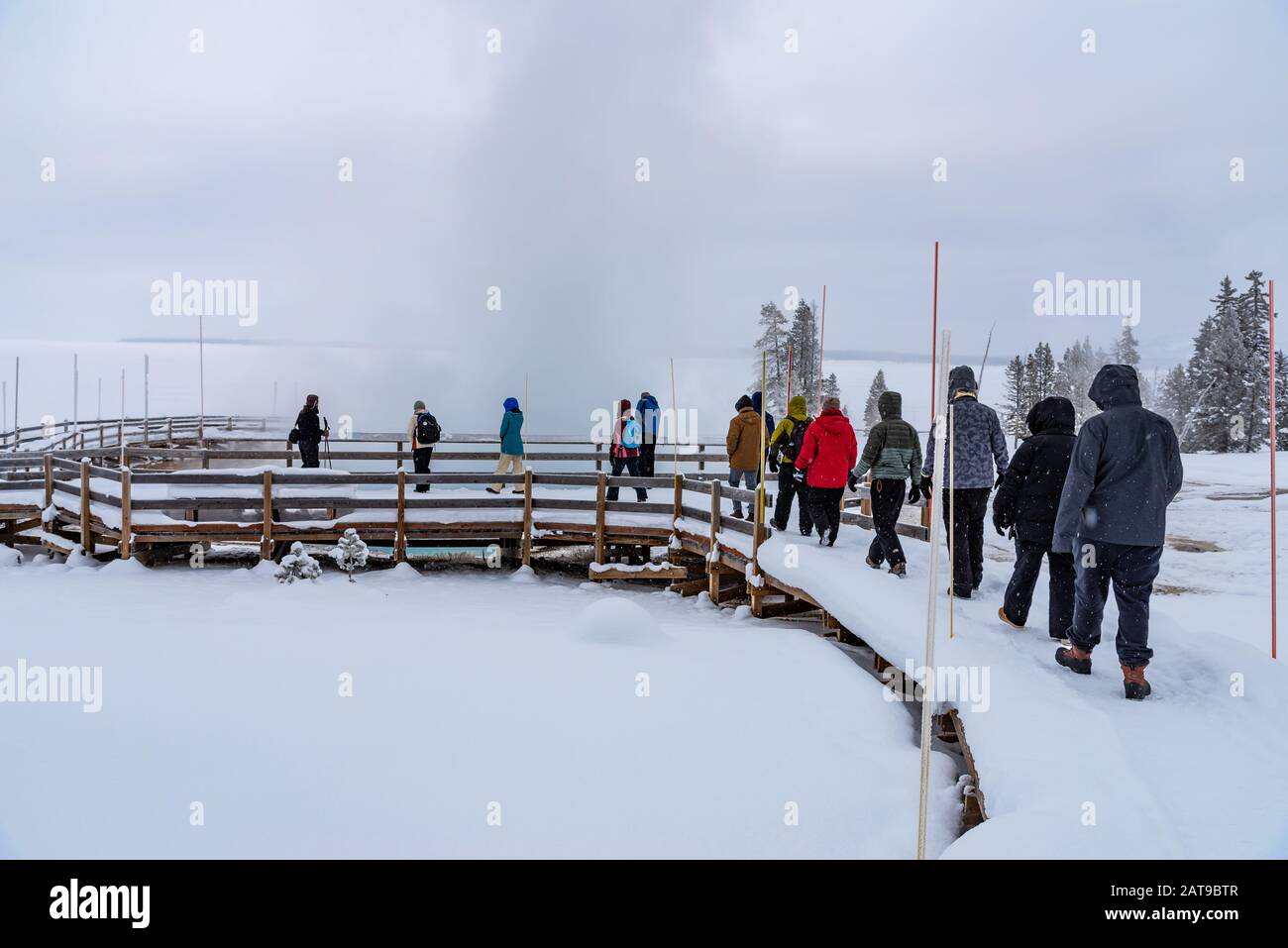 Un guide touristique dirige un groupe de visiteurs sur la promenade en hiver. Yellowstone National Park, Wyoming, États-Unis Banque D'Images