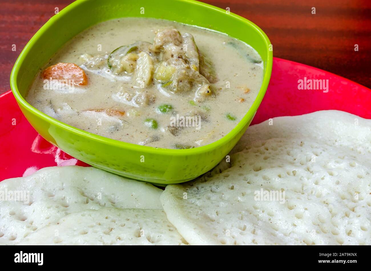 Petit déjeuner spécial Kerala, ragoût de poulet et appams. Banque D'Images