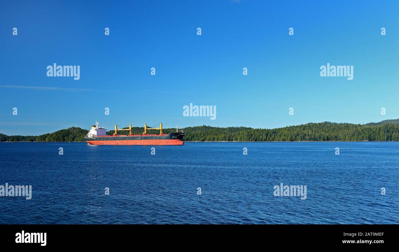 Ocean cargo sur l'eau bleue avec une île pour l'arrière-plan Banque D'Images