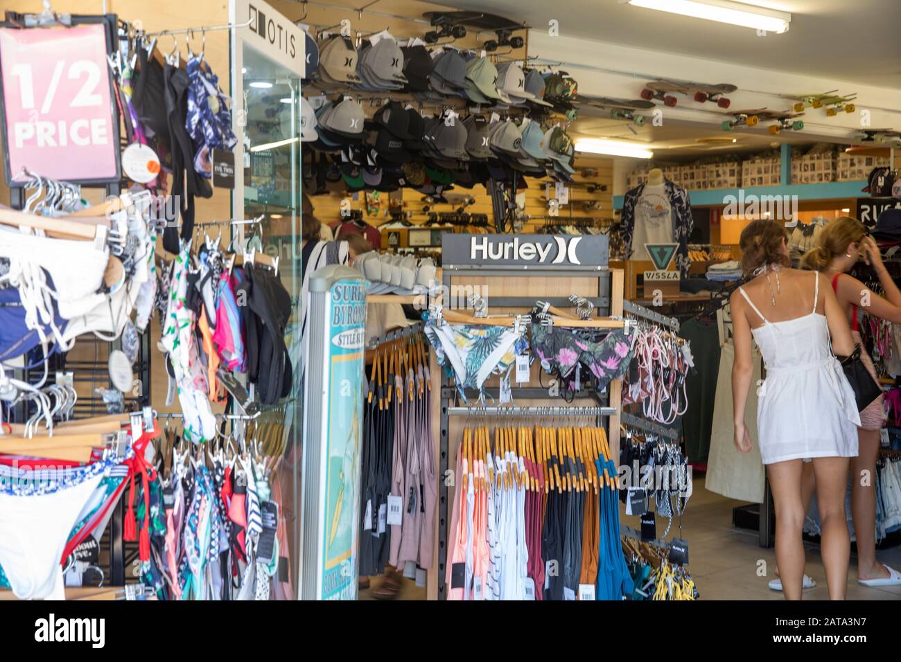 Les adolescentes magasiner dans un magasin de vêtements de surf à Byron Bay Australie en été, équipement sportif hurley Banque D'Images