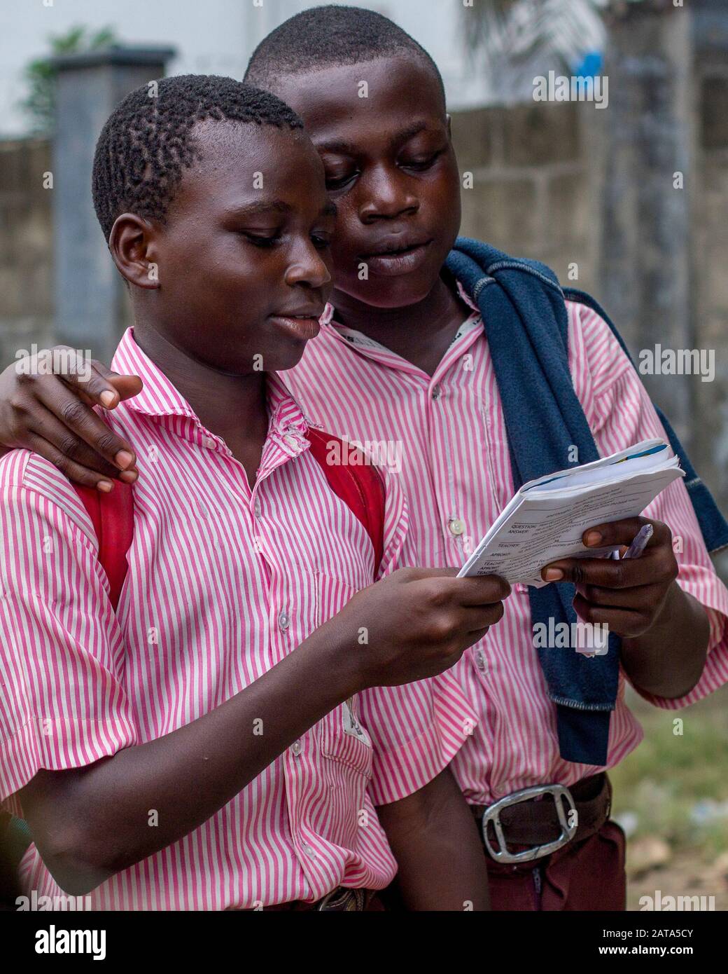 Deux garçons lisent un livre sur leur chemin de retour de l'école. Banque D'Images
