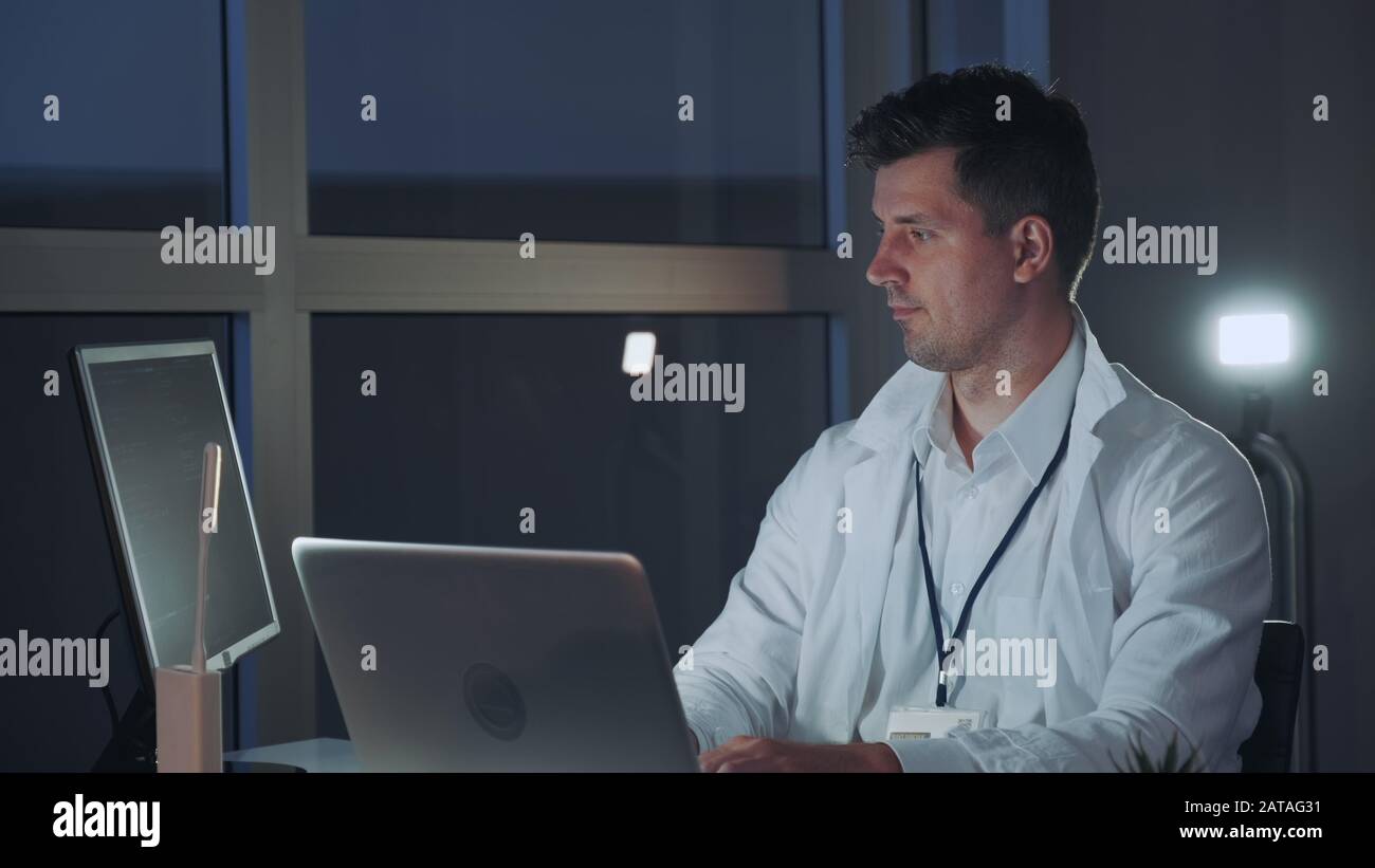 Spécialiste masculin de l'électronique travaillant sur l'ordinateur en laboratoire moderne. Il a trouvé de nouvelles méthodes technologiques. Rédaction Professionnelle Sur Le Code De Programmation Banque D'Images