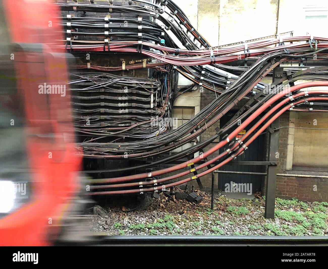 Londres, Royaume-Uni - 26 janvier 2020 : un train souterrain arrive à côté du câblage électrique de la station de métro London Edgware Road. Banque D'Images