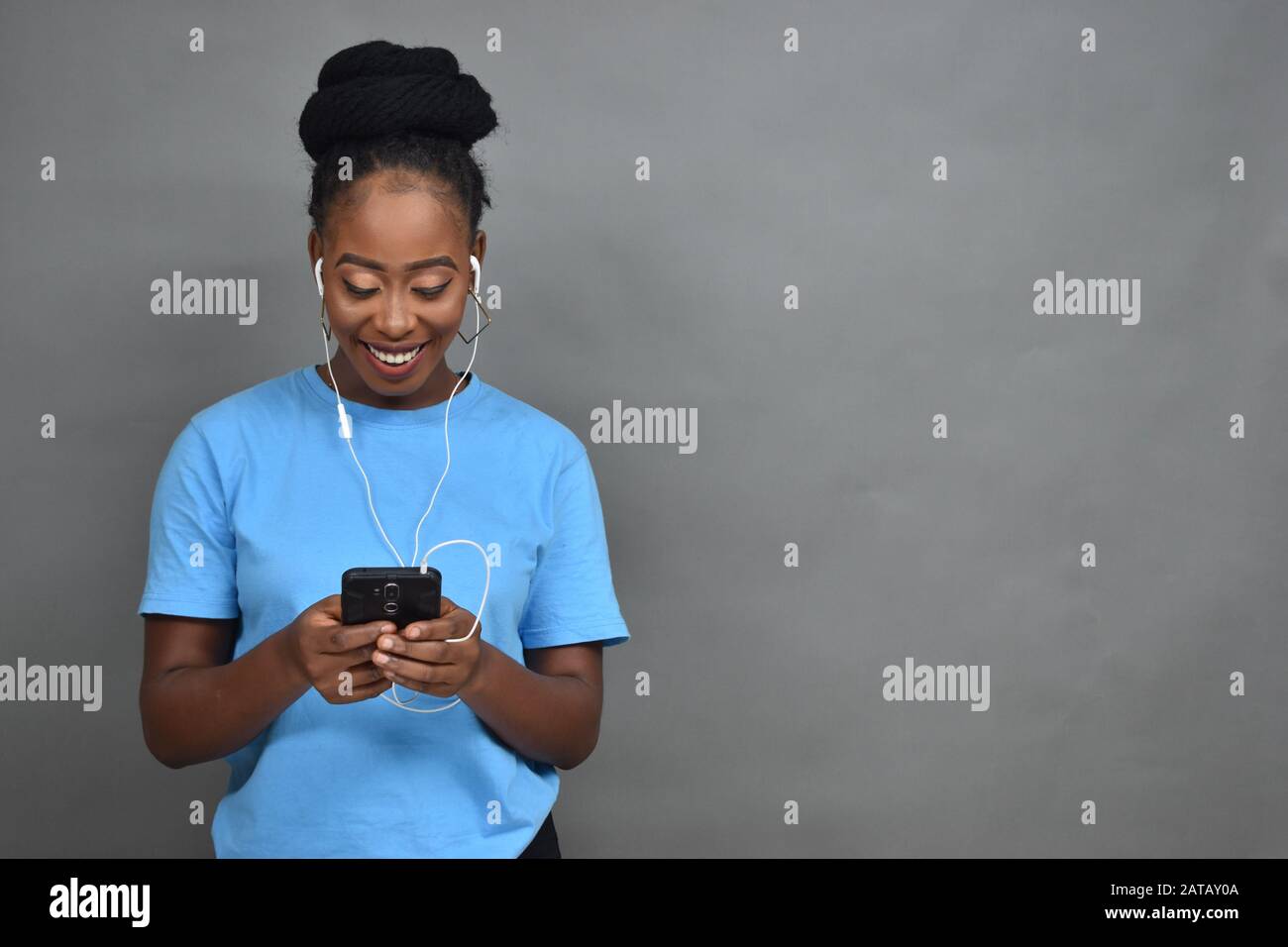 jolie jeune femme noire à écouter de la musique avec son téléphone portable Banque D'Images