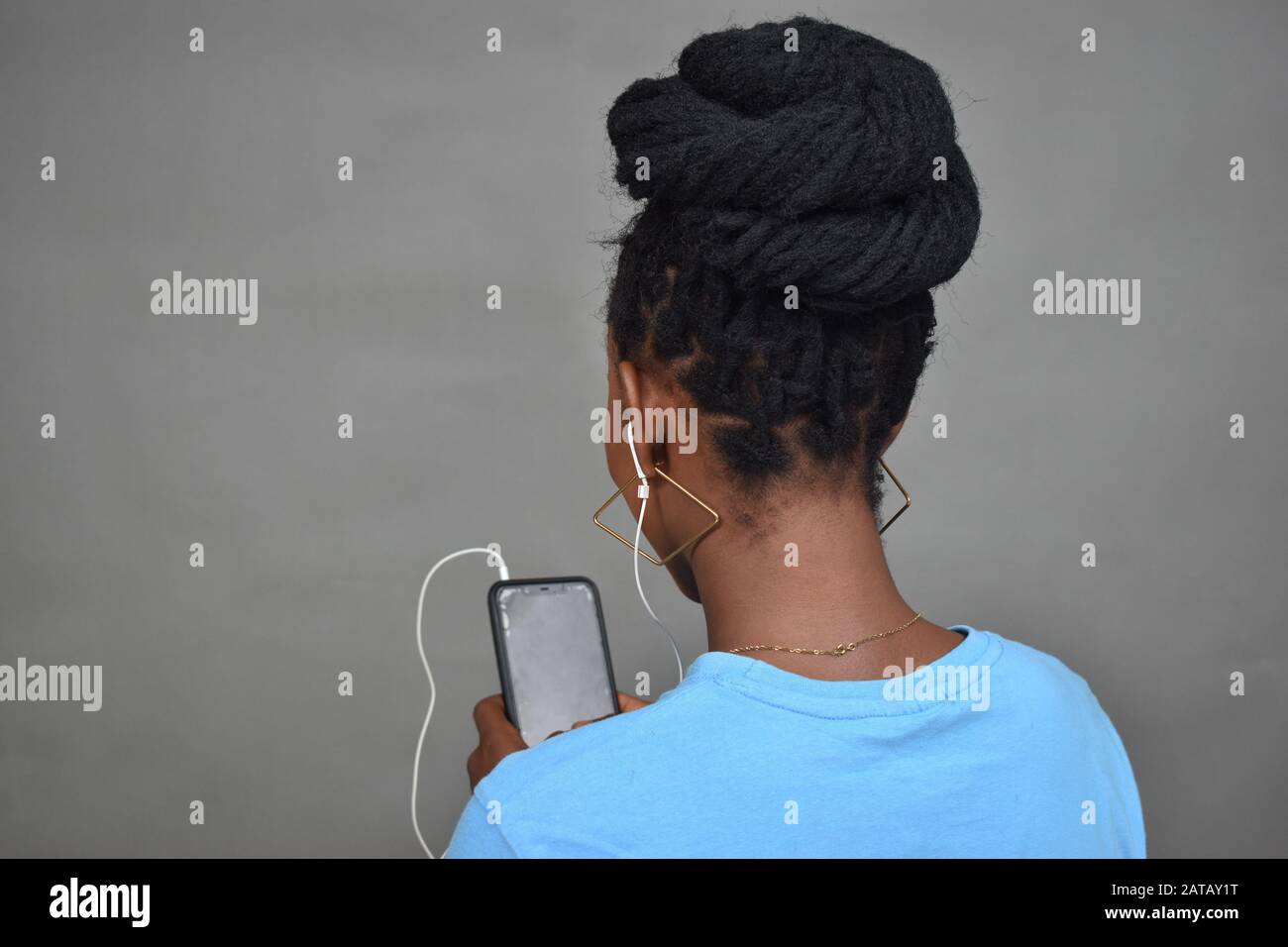 jeune femme noire avec coiffure africaine à l'écoute de la musique, vue arrière Banque D'Images
