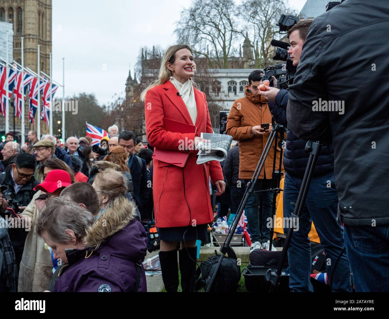 Le 31 janvier 2020, jour du Brexit, et les gens se rassemblent sur la place du Parlement, Londres, Angleterre, comme une journaliste féminine fait un morceau à la caméra et sourit. Banque D'Images