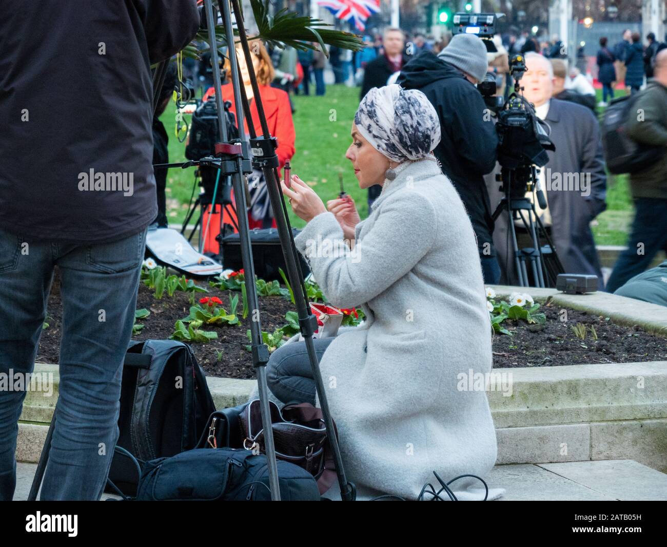 Le 31 janvier 2020, jour du Brexit, et les gens se rassemblent sur la place du Parlement, Londres, Angleterre, alors qu'un journaliste assiste à son maquillage. Banque D'Images