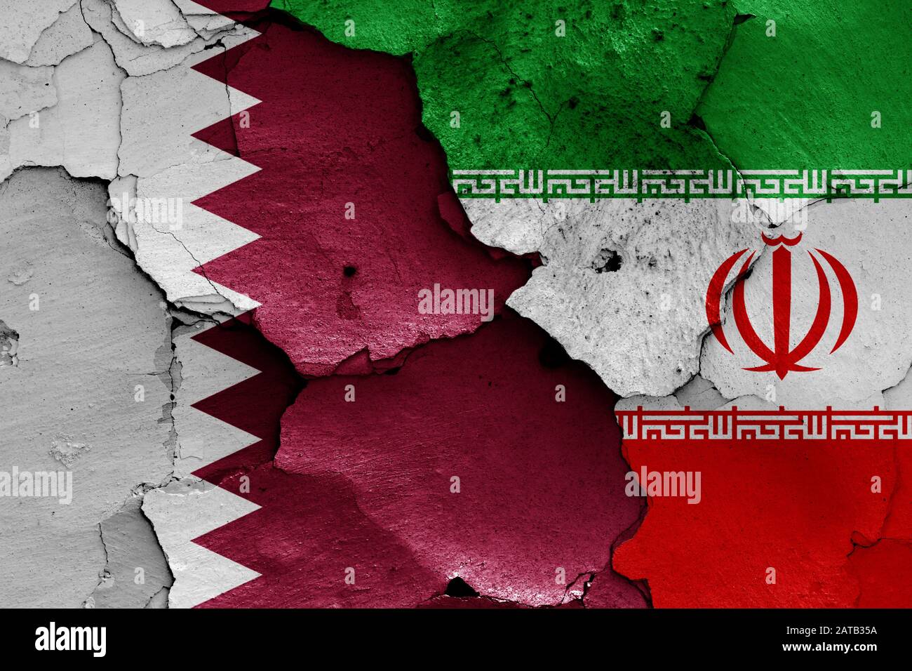 Drapeaux du Qatar et de l'Iran peints sur un mur fissuré Banque D'Images