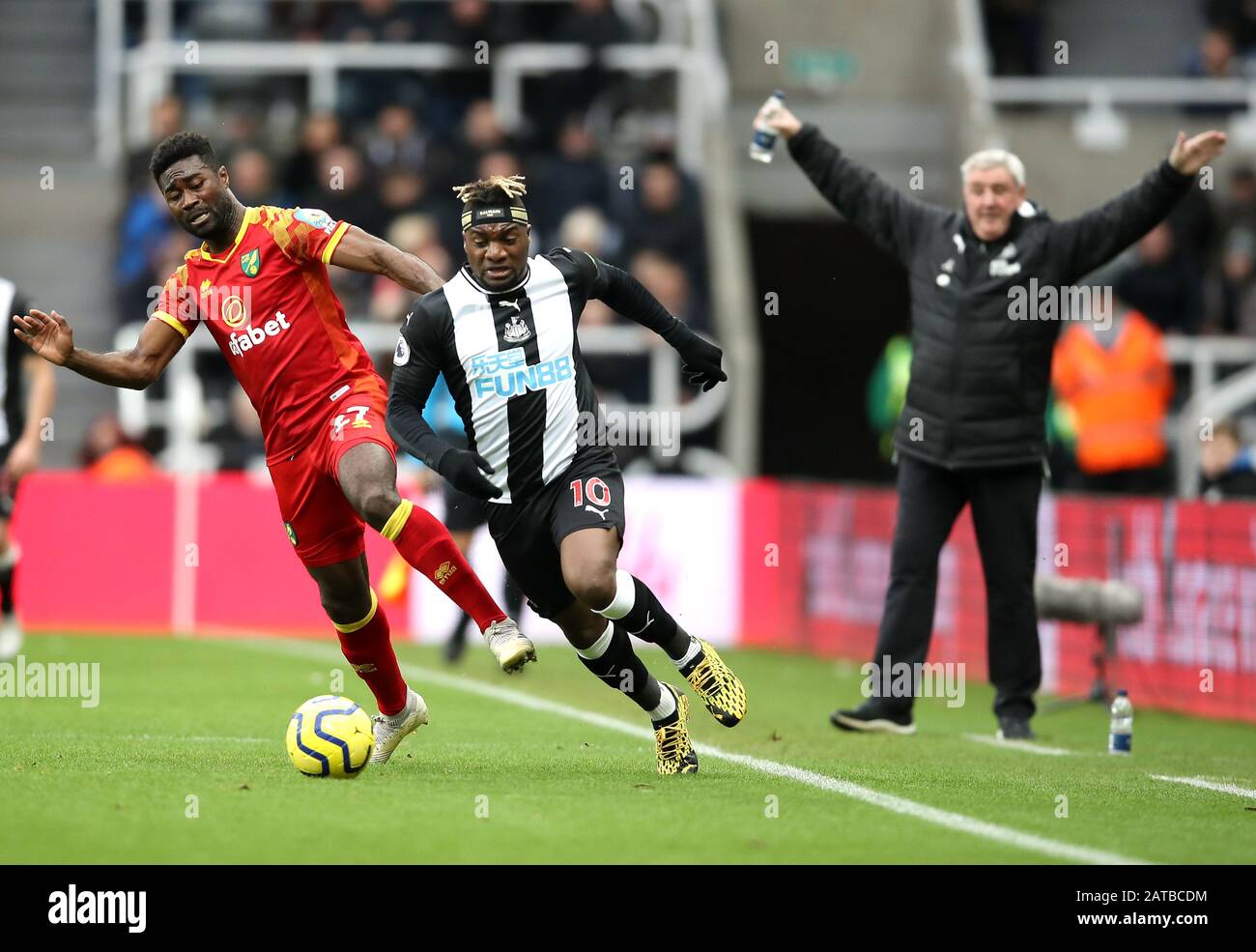 Alexander Tettey (à gauche) de Norwich City et Allan Saint-Maximin de Newcastle United combattent pour le ballon, tandis que Steve Bruce, le directeur de Newcastle United, se présente lors du match de la Premier League à St James Park, à Newcastle. Banque D'Images