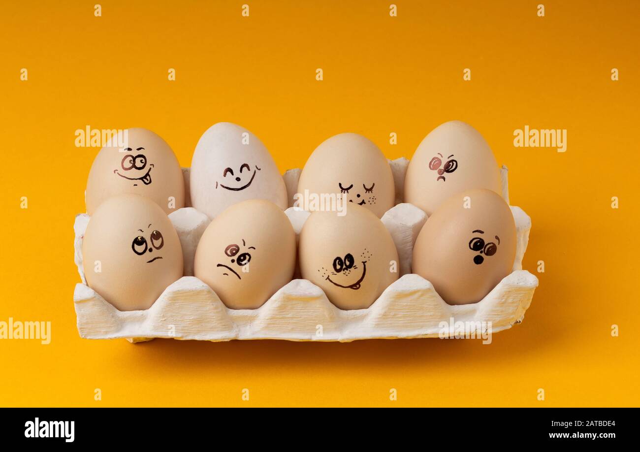 Oeufs de poulet Avec des smileys Pour la peinture de Pâques sur fond jaune Banque D'Images Oeufs de poulet Avec des smileys Pour la peinture de Pâques sur fond jaune Banque D'Images