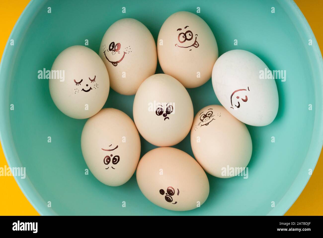 Ensemble d'œufs émotionnels de conception pour Joyeuses Pâques dans un arc de couleur menthe aquatique sur fond jaune. Vue de dessus Banque D'Images