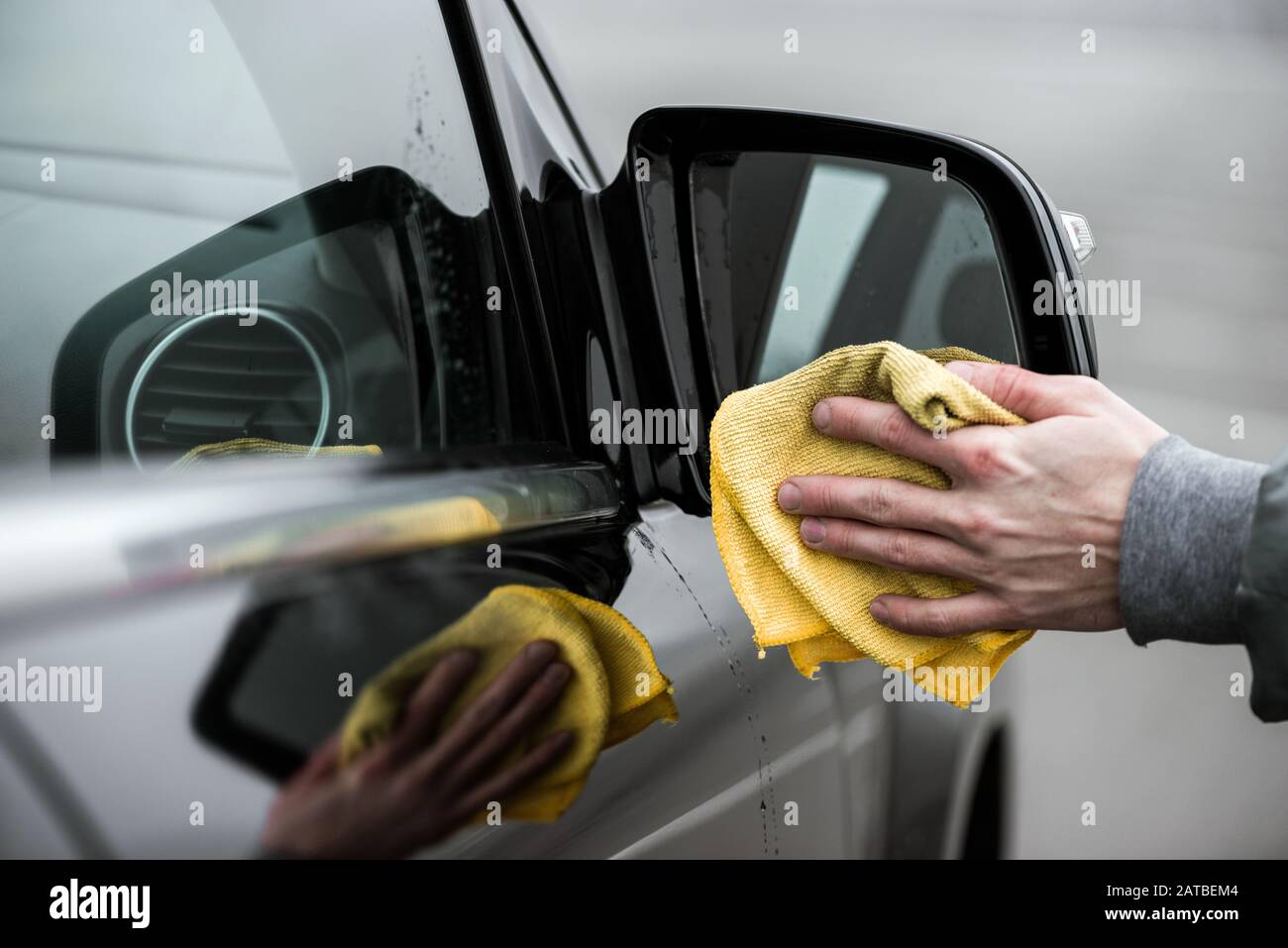 Un miroir de voiture de nettoyage pour homme avec tissu en microfibre, concept de détails de voiture. Banque D'Images