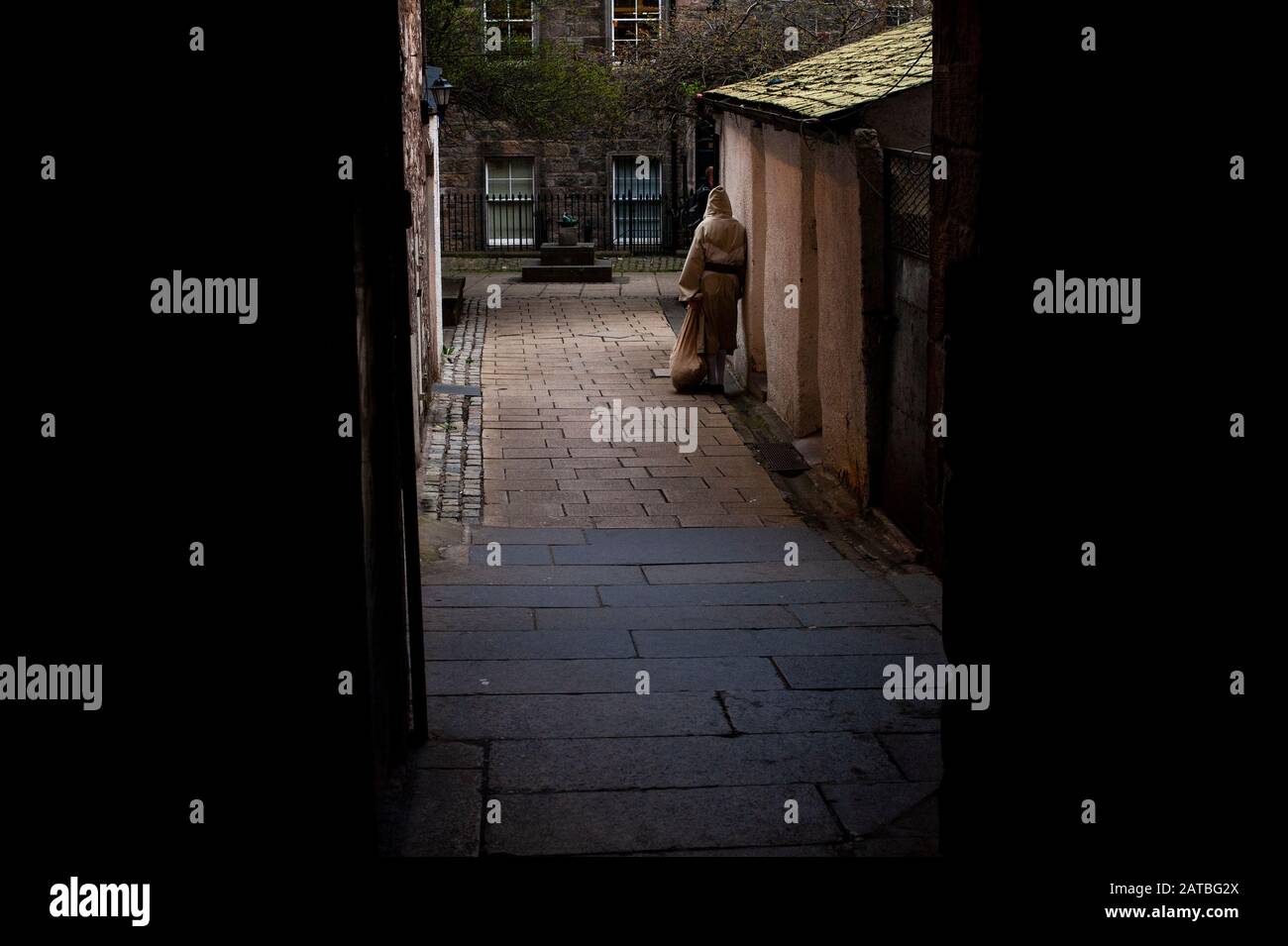 Un guide touristique habillé comme un moine attendent que les touristes arrivent et les effarent dans la cour James. Photographie de voyage/paysage urbain d'Édimbourg par Pep Masip. Banque D'Images
