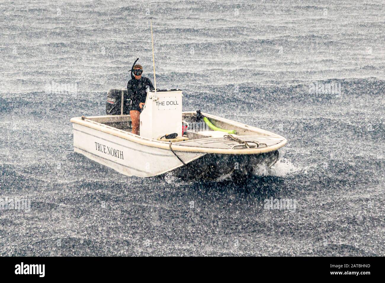 Bateau sur l'océan sous la pluie. Heureusement, une douche tropicale ne dure pas longtemps dans les mers du Sud. Mais assez de temps pour mettre sur les lunettes de plongée pour la photo Banque D'Images