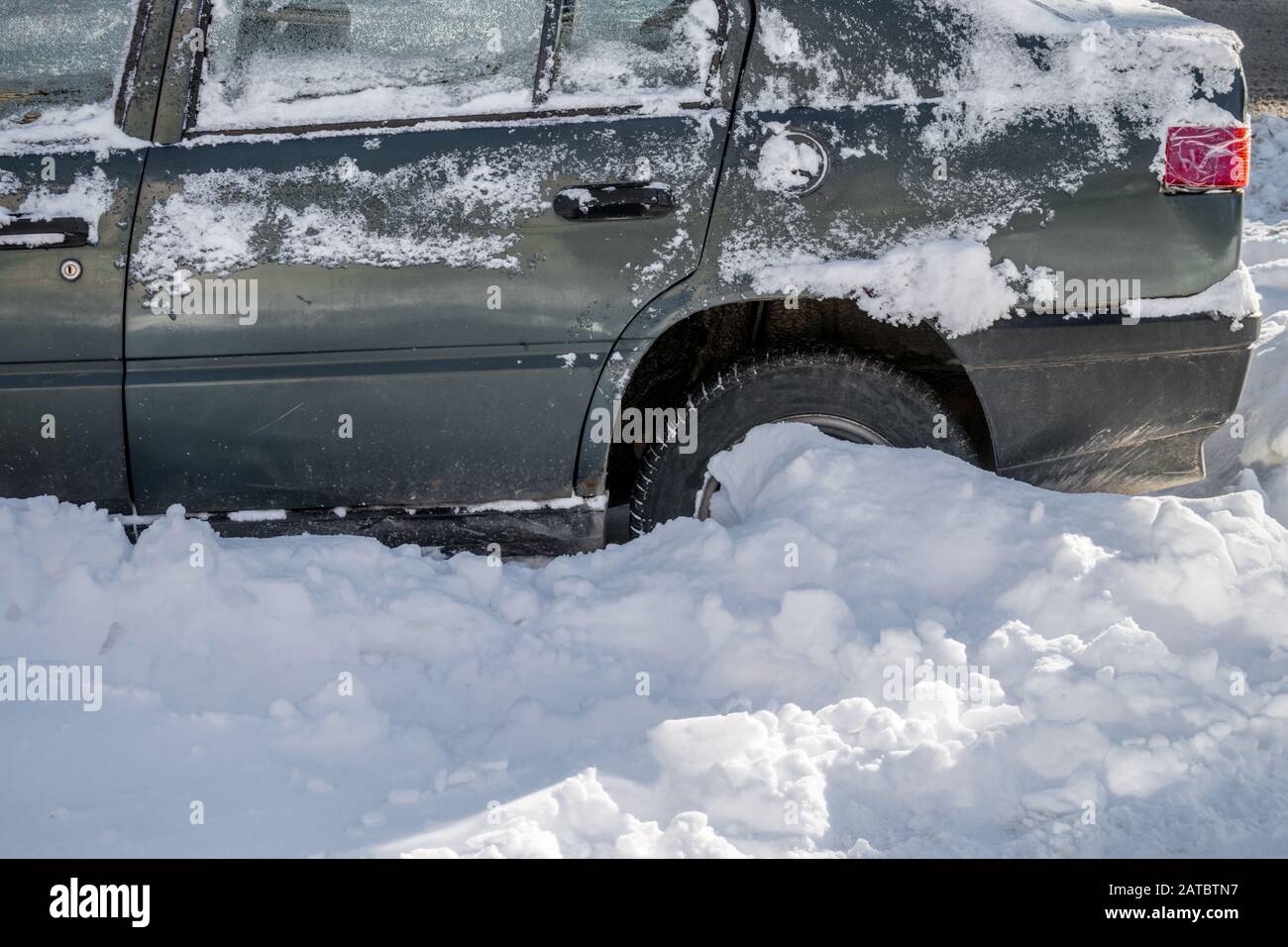 La roue arrière de la voiture patine dans un jet de neige. Concept de problèmes de transport par temps enneigé Banque D'Images
