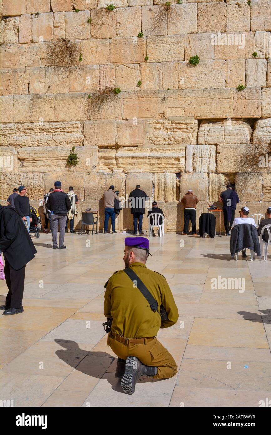 Un soldat armé à Jérusalem, en Israël, arbalète devant le mur occidental, le site le plus sacré du judaïsme, le jour ensoleillé. Les Juifs prient au mur des souffleurs Banque D'Images