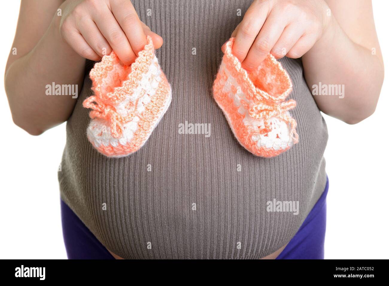 Femme enceinte tenant une belle chaussures de bébé en laine isolée sur blanc Banque D'Images Femme enceinte tenant une belle chaussures de bébé en laine isolée sur blanc Banque D'Images