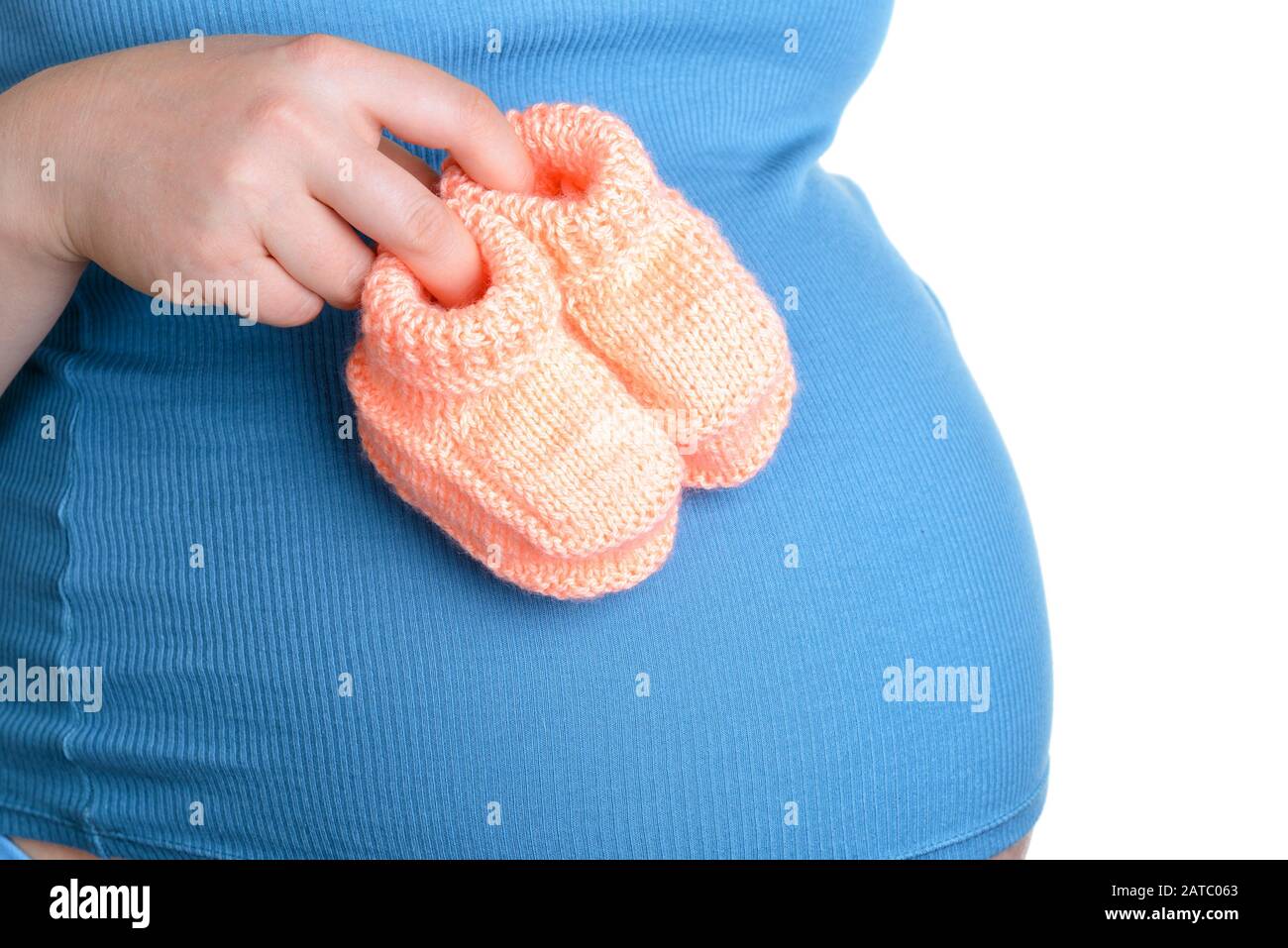Femme enceinte tenant une belle chaussures de bébé en laine isolée sur blanc Banque D'Images Femme enceinte tenant une belle chaussures de bébé en laine isolée sur blanc Banque D'Images