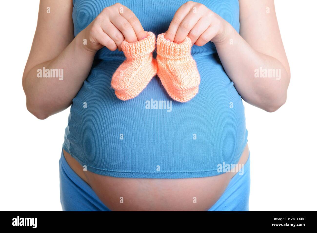 Femme enceinte tenant une belle chaussures de bébé en laine isolée sur blanc Banque D'Images