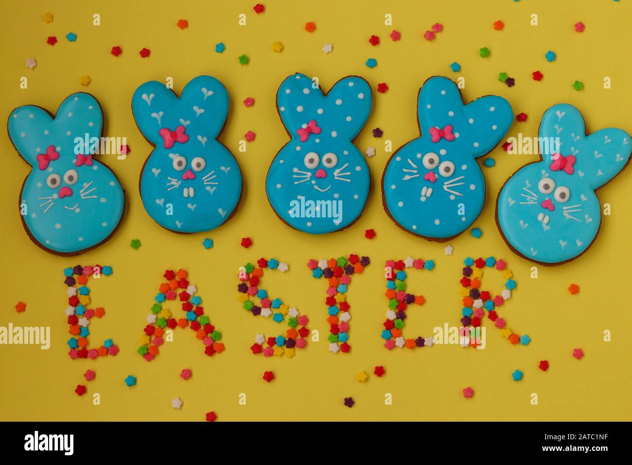 Pâques lapins bleus drôles, biscuits faits maison au pain d'épices peints en glacer sur un fond jaune Banque D'Images