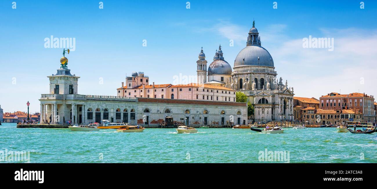 Vue panoramique sur le Grand Canal avec bateaux-taxis et église Santa Maria della Salute à Venise, Italie. Les bateaux à moteur sont le principal moyen de transport à Venise. Banque D'Images