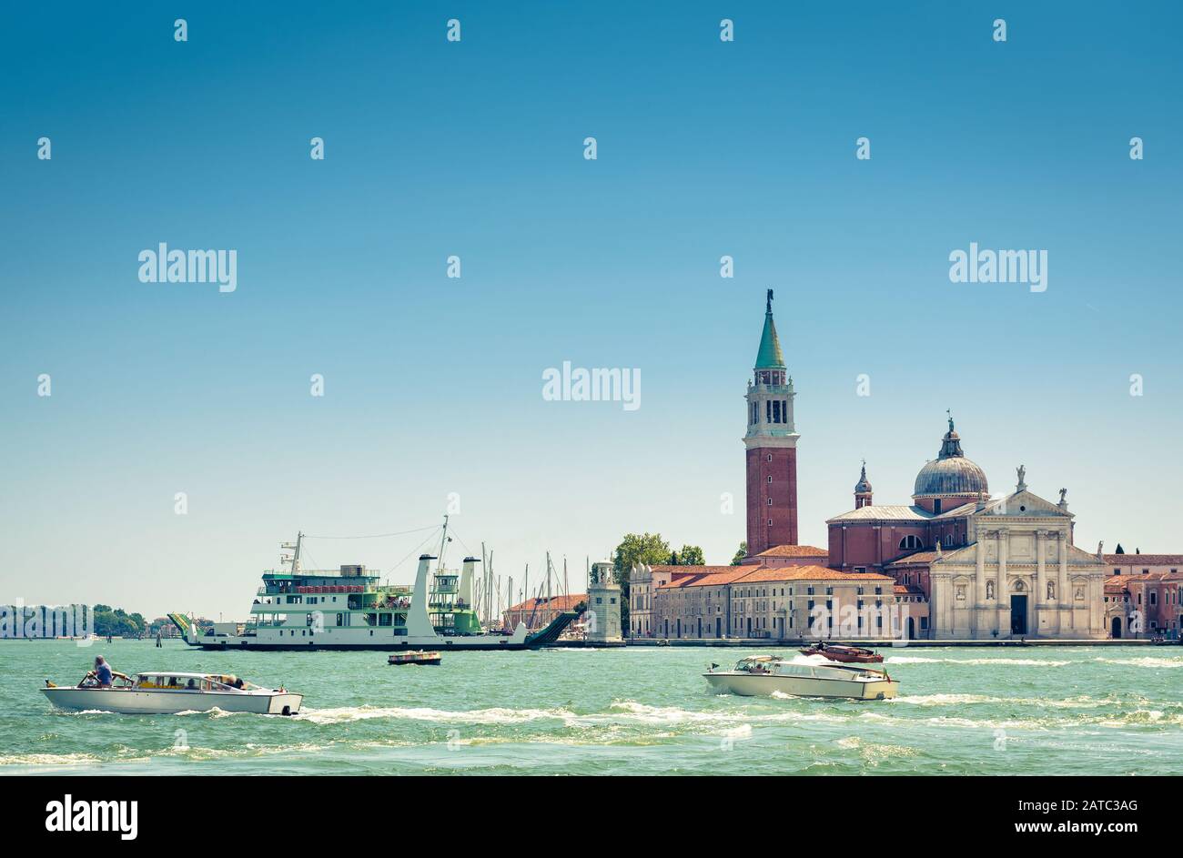Venise le jour ensoleillé de l'été, Italie. Des bateaux à moteur naviguent au-delà de l'île San Giorgio Maggiore à Venise. Panorama de la lagune de Venise avec ciel bleu pour l'arrière-gro Banque D'Images