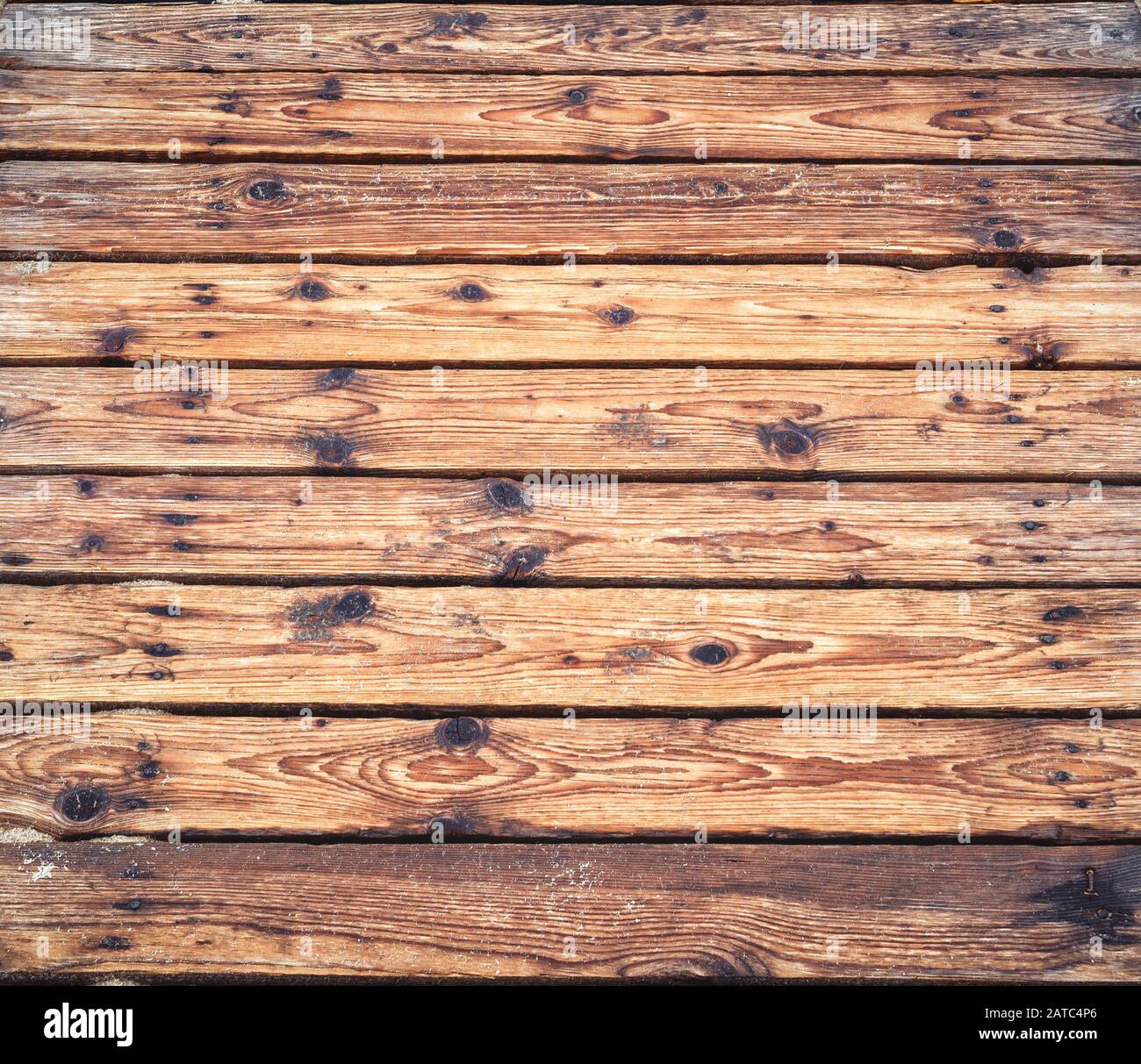Terrasse en bois sur une plage de sable de gros plan. Bois rugueux planks arrière-plan. Surface de vieux bois noué avec couleur naturelle, texture et motif. Vue de dessus Banque D'Images