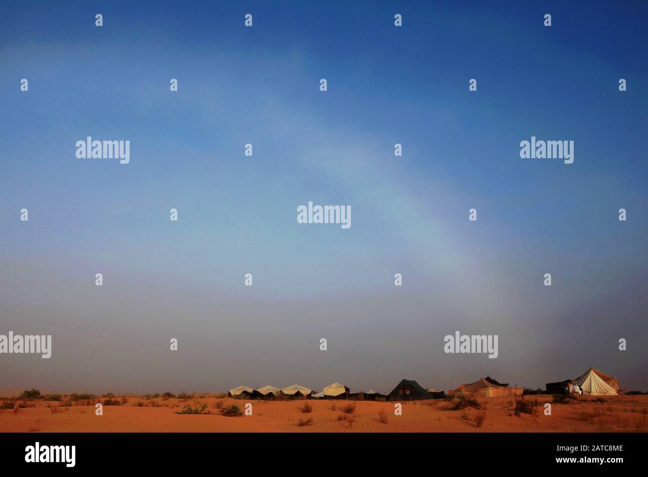 Le fogbow se courbe sur le ciel au-dessus du camp de tente et des dunes de sable au Sahara Banque D'Images